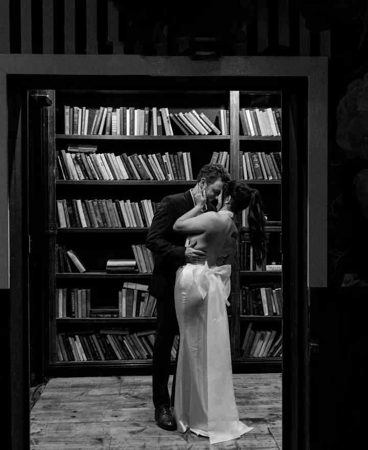 Bride and groom embrace in a library in fashionable wedding day at Ever After Ranch