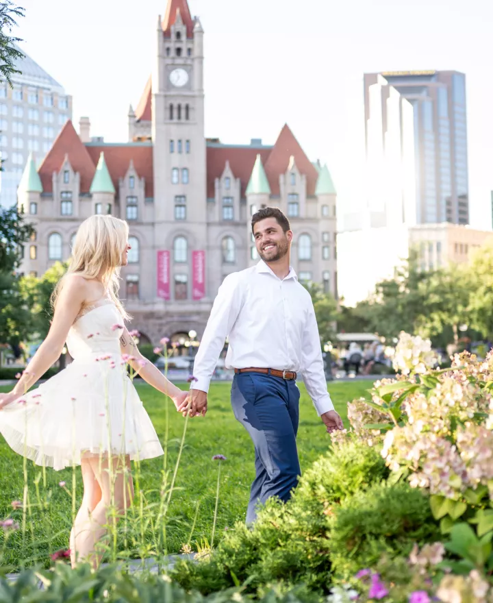Katie and Zachary celebrate their engagement by prancing around the park in front of Landmark Center in St. Paul