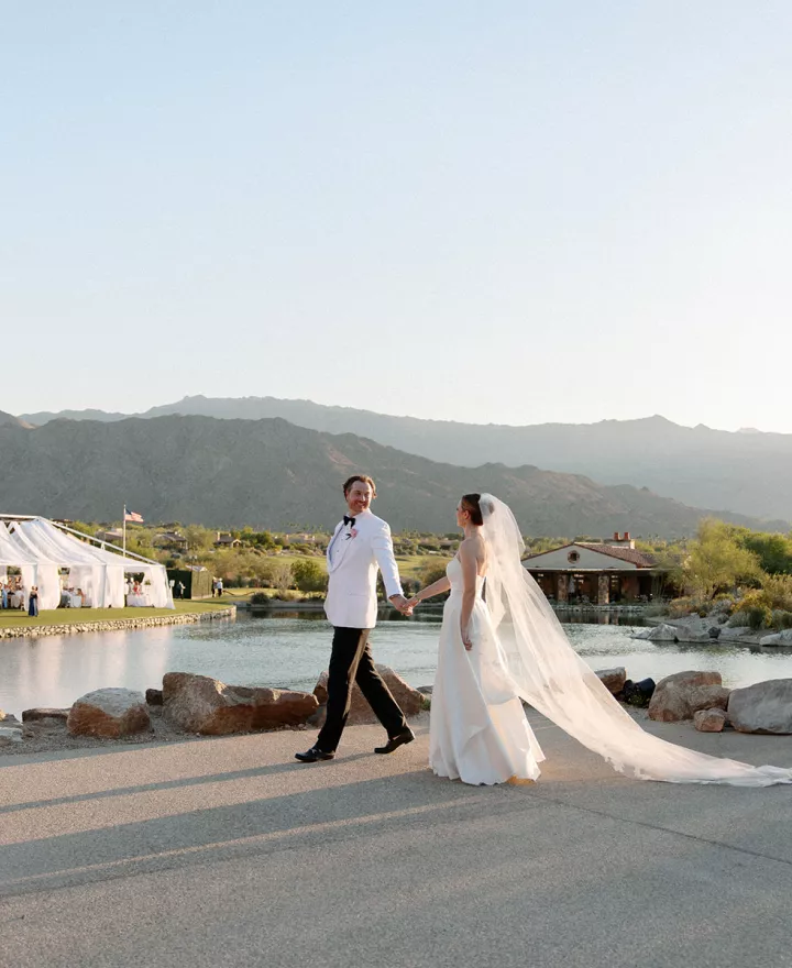 Emily and Vladimir cross the grounds of The Reserve Club during golden hour on their wedding day