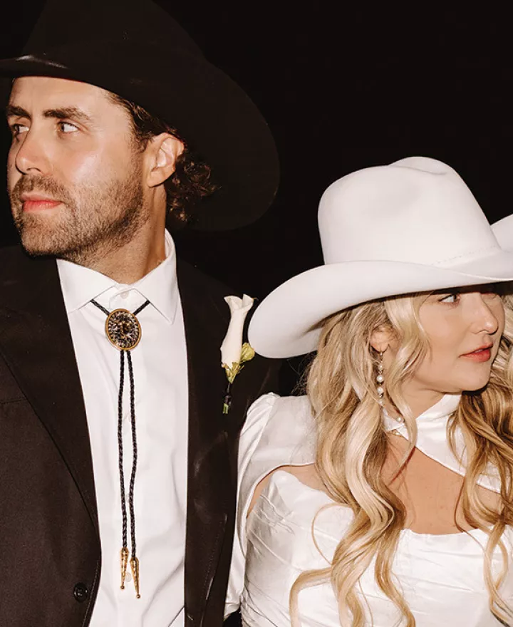 Morgan and Justin pose in their western hats at their wedding reception