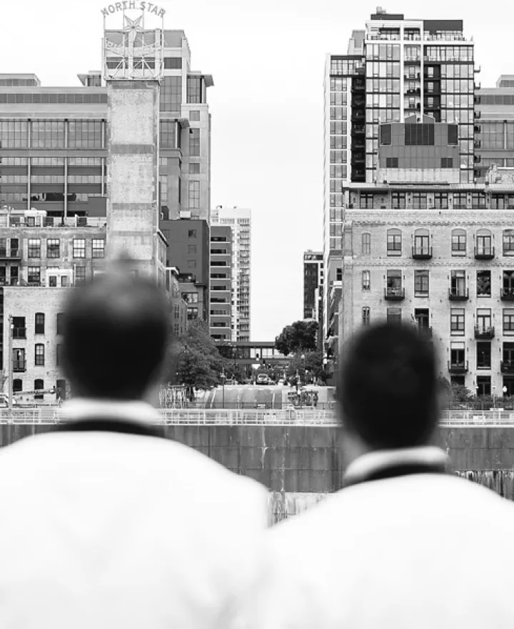 Matt and Luke lean on each other against the Minneapolis skyline