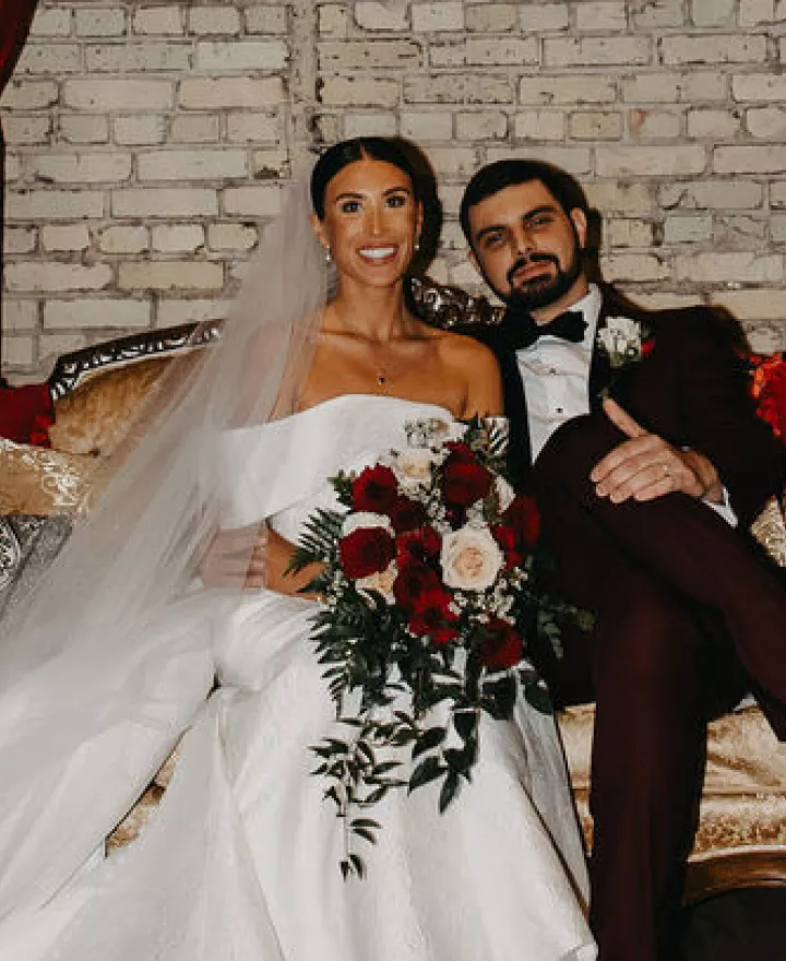 Kara and Jordan pose on a lounge vignette on their wedding day