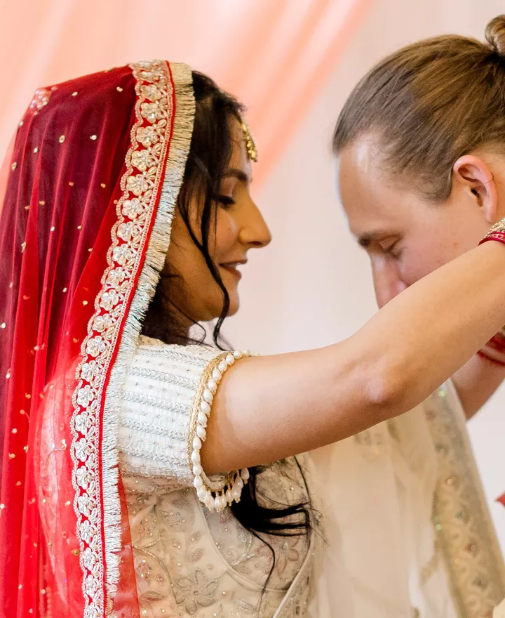 Shipra places a garland around Grant's neck during wedding ceremony