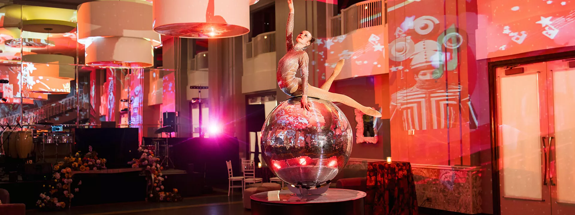 Entertainer balances on disco ball in lively, colorful reception at The Beach Club