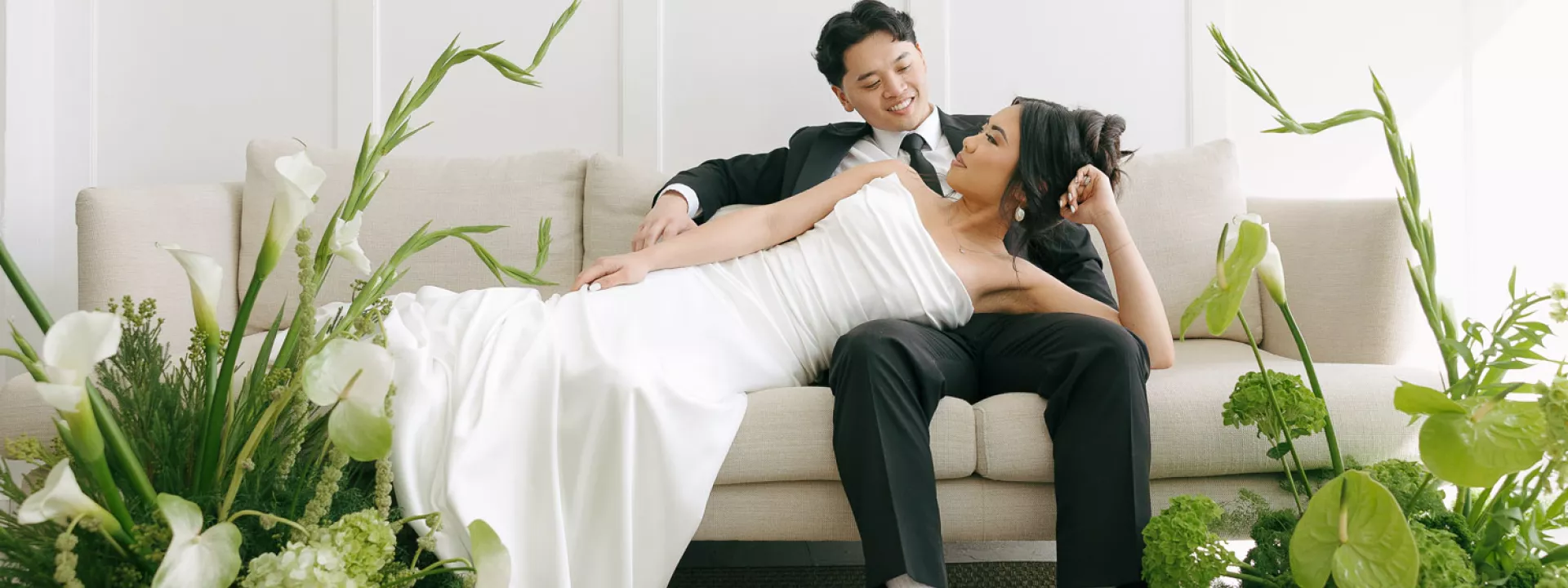 Models Lounge on Couch Surrounded by Lush Green Florals in Styled Shoot at 210 Seattle