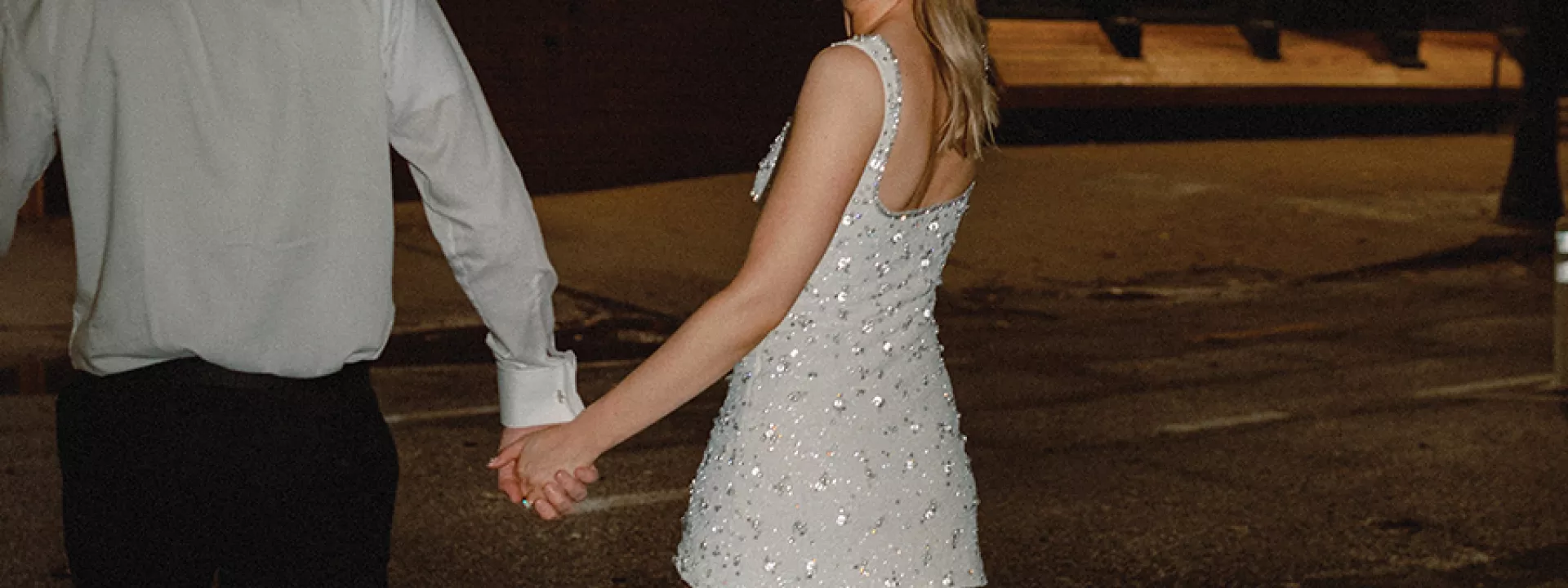 Bride and groom holding hands at their reception