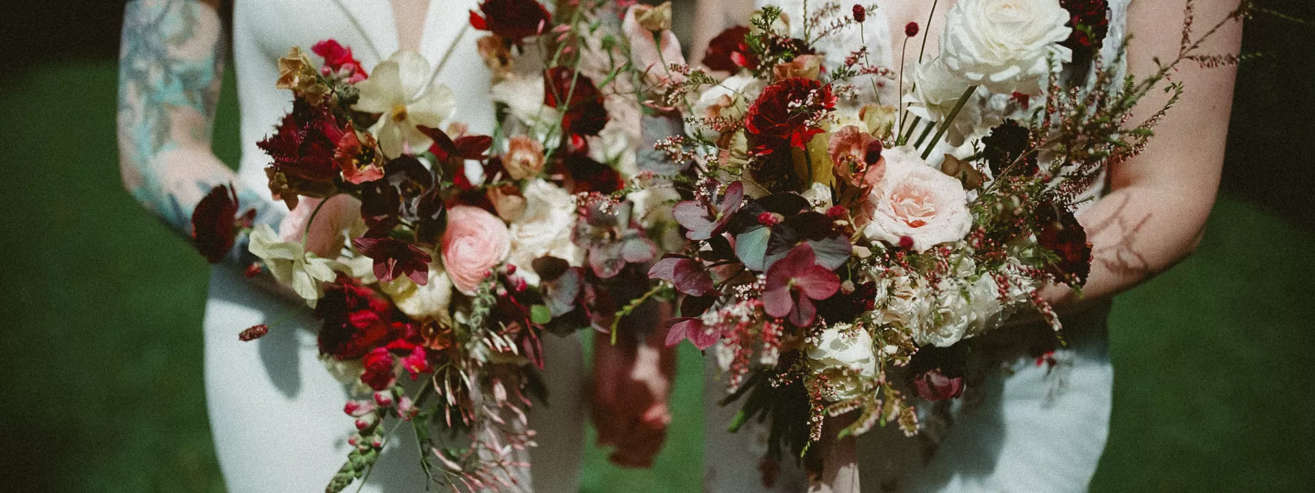 Two coordinating bridal bouquets in marsala wine colors for two brides