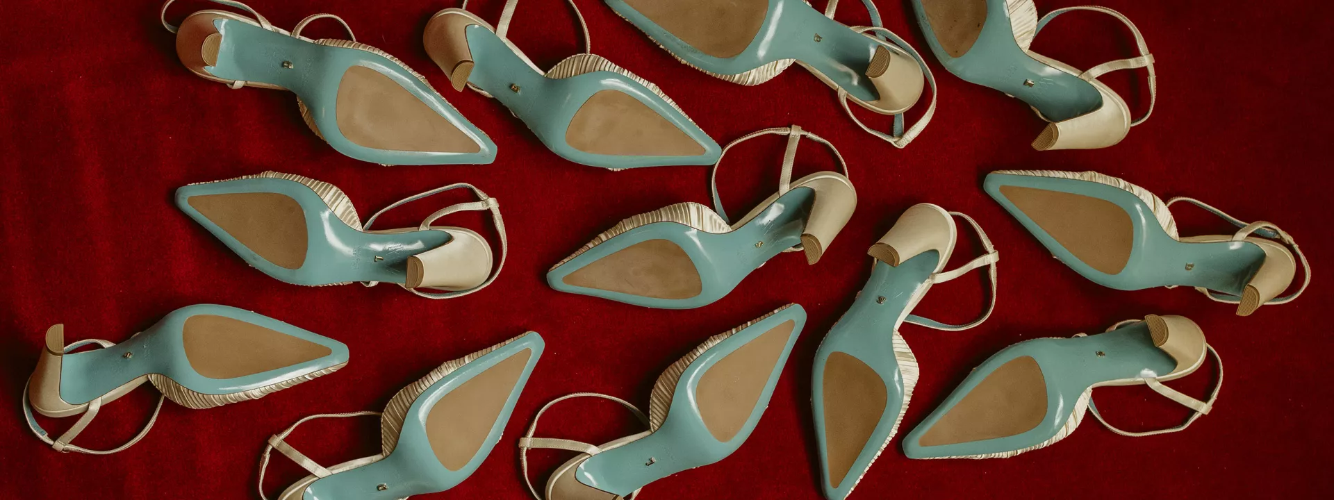 Six pairs of Valentina Rangoni designed shoes, soles up on a red carpet 