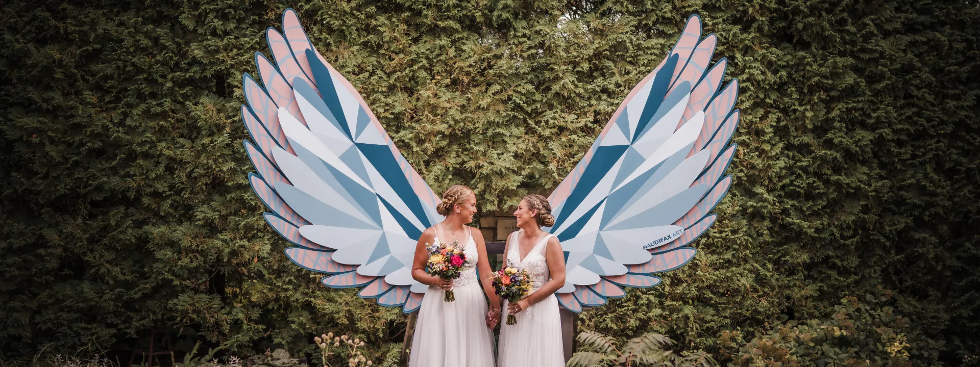 Brides stun in coordinating wedding attire amongst lush greenery