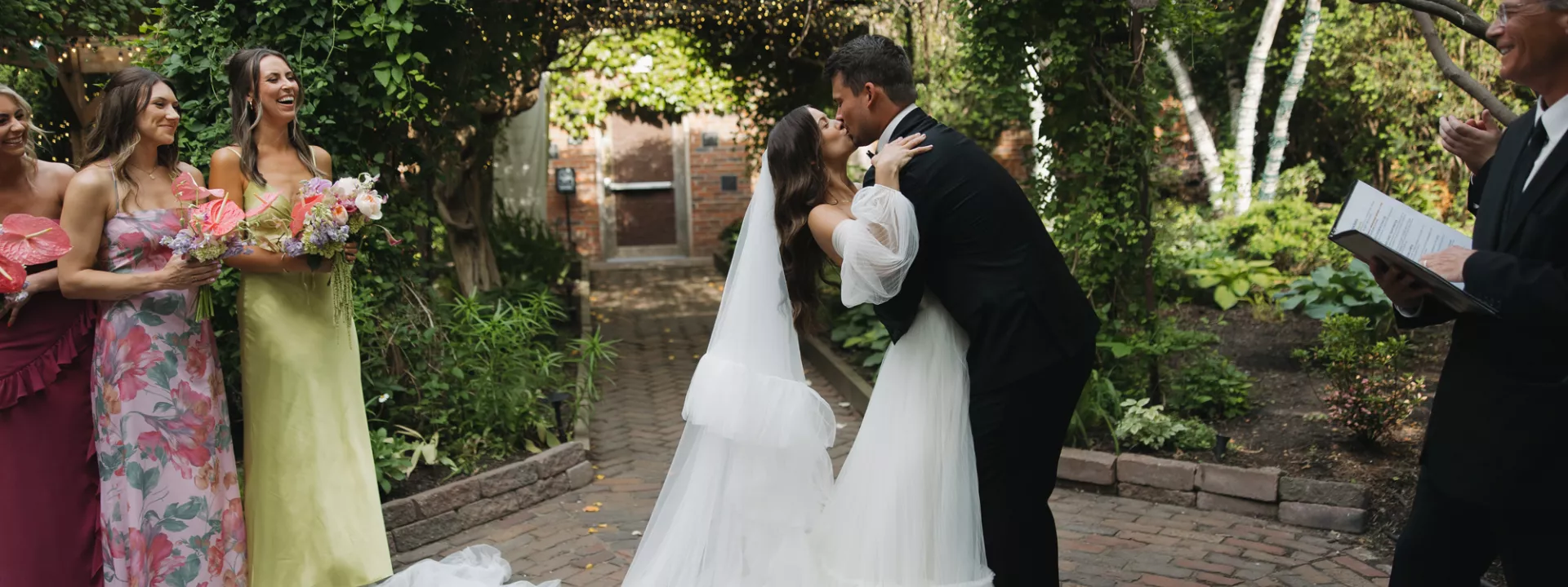 Bride and groom share a kiss after exchanging vows under an ivy trellis at The Bohemian Gardens