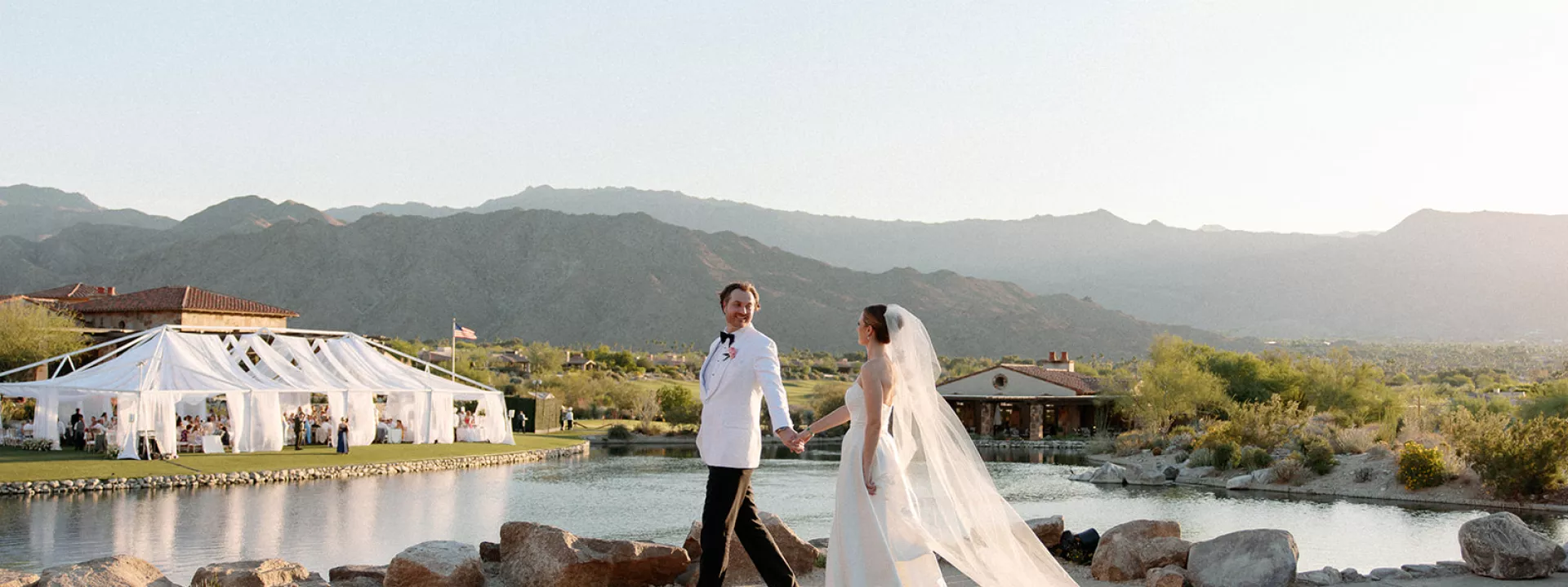 Emily and Vladimir cross the grounds of The Reserve Club during golden hour on their wedding day