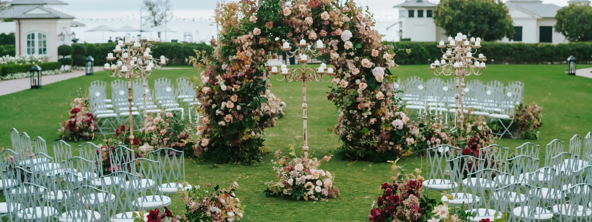 Outdoor wedding ceremony setup on The Great Lawn at Rosewood Miramar Beach with a circular floral arch and pastel-toned flowers
