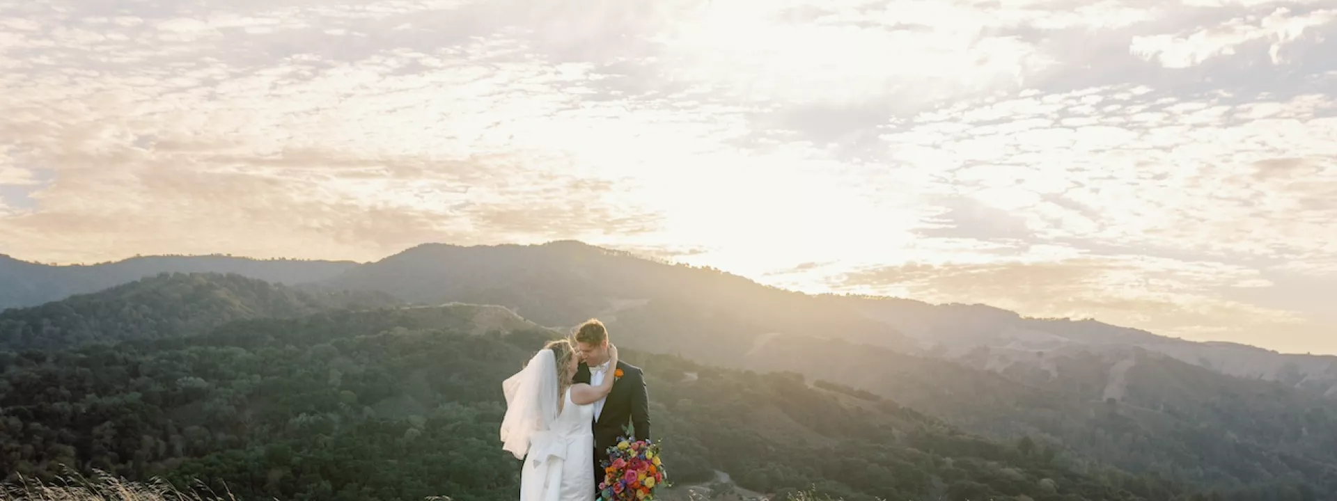 Katie and Sam Overlooking the Mountainous Santa Lucia Preserve in Colorful Wedding