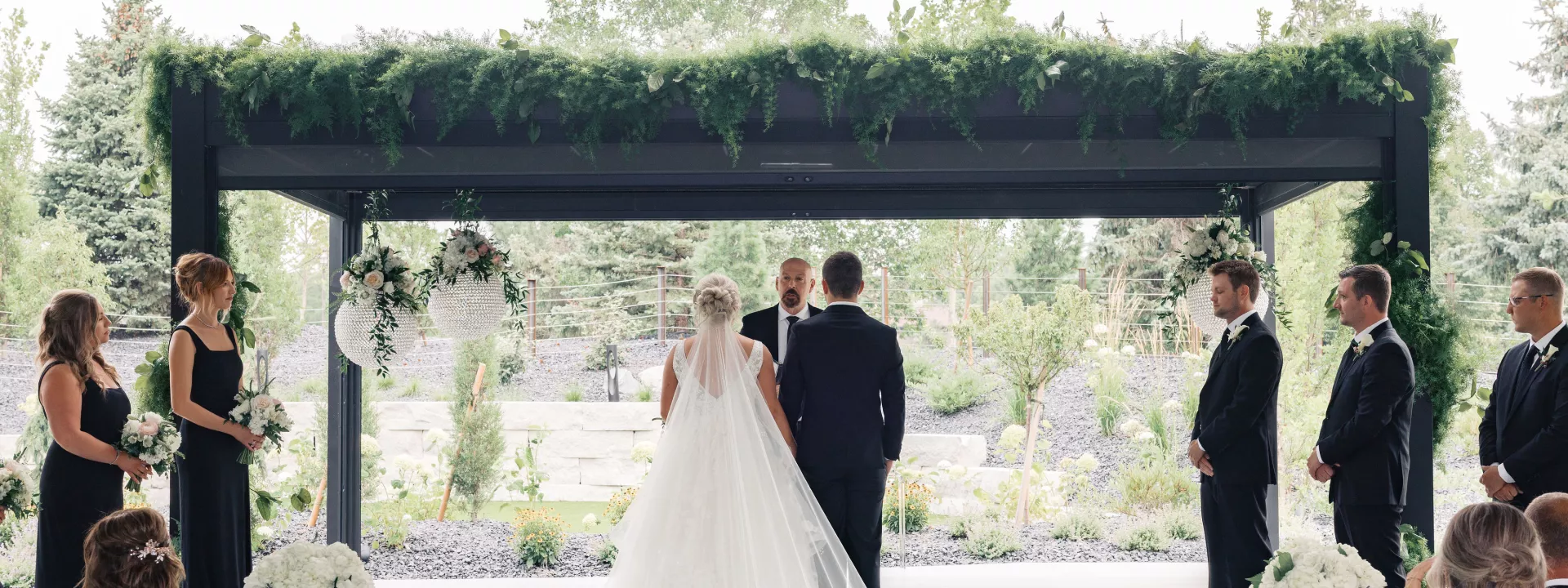 Bride and groom stand with backs facing the ceremony while standing at rectangular altar at Venue 5 Twenty-Two