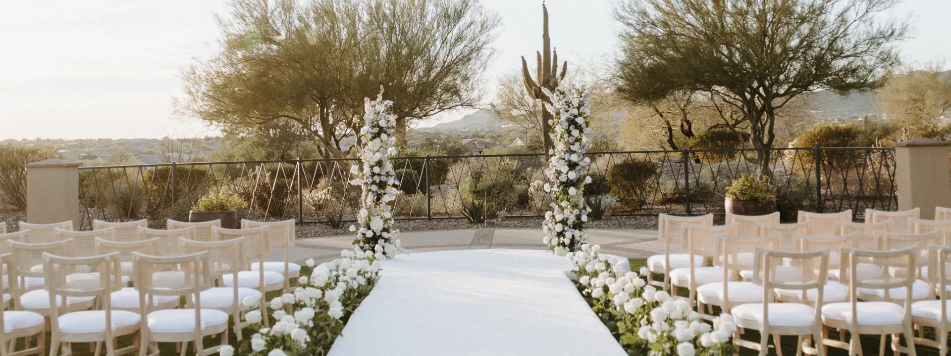 Ceremony space looking over Peoria's native plants, white roses lining the aisle
