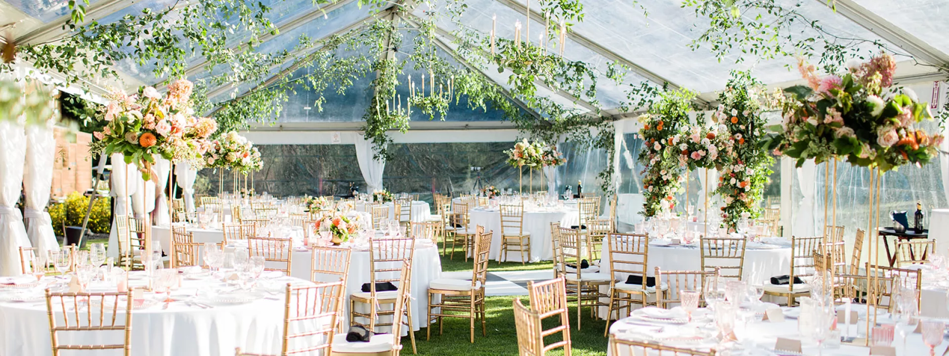 Tented reception space featuring greenery and lush florals at Tumble Creek