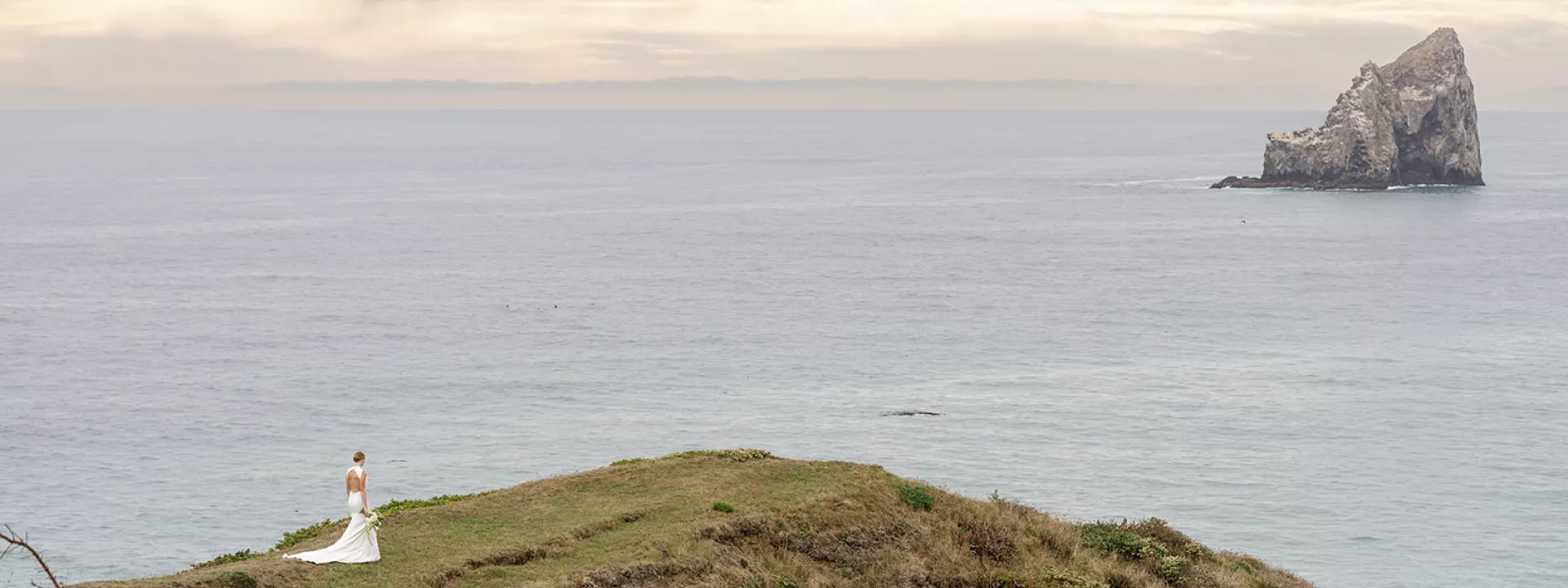 Model walks along the cliffs of Crook Point with the great expanse of water in the backdrop
