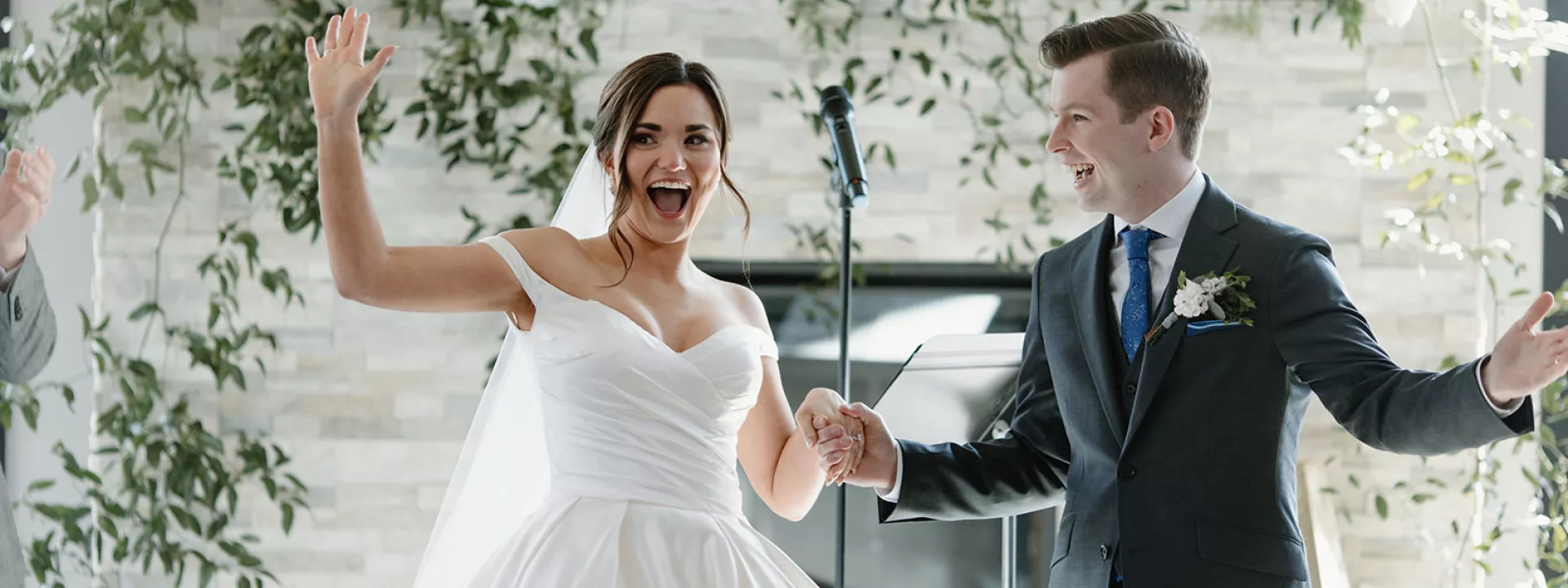 Bride and groom smile as they walk back down the aisle at the Skyroom