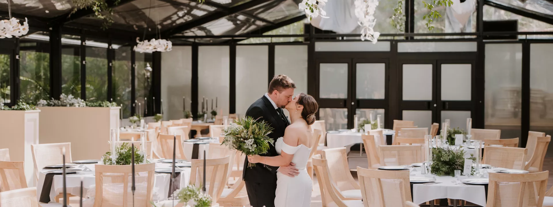 Bride and groom embrace amidst their foliage-forward, modern wedding day at Woodland Glasshouse