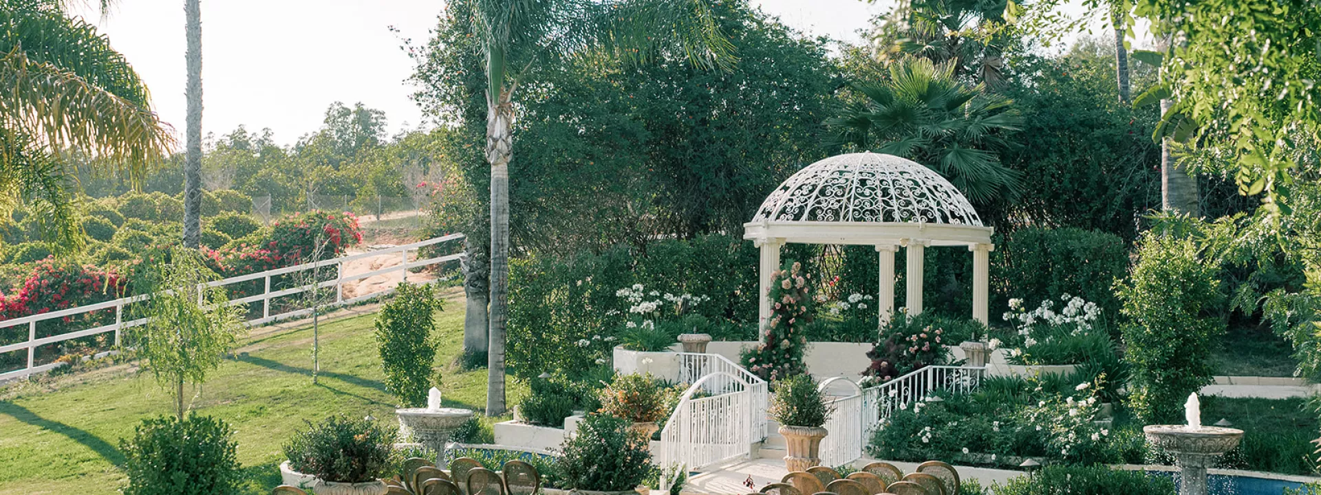 Sun-soaked outdoor imagined ceremony featuring deep moody floral palette and crisp white pergola at the center on the grounds of Villa Zosaneli