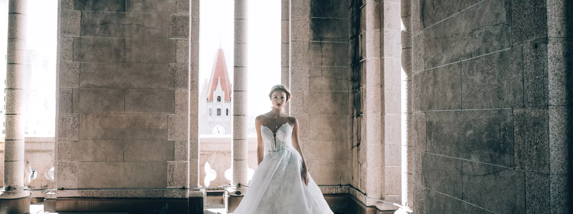 Model in lace ballgown poses in Landmark Center venue