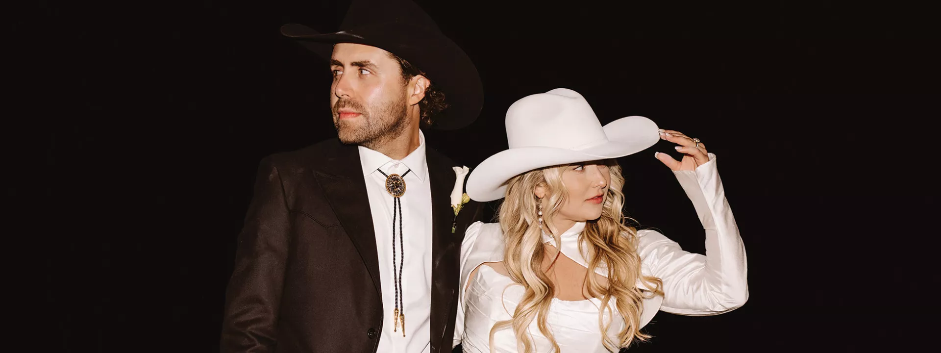 Morgan and Justin pose in their western hats at their wedding reception
