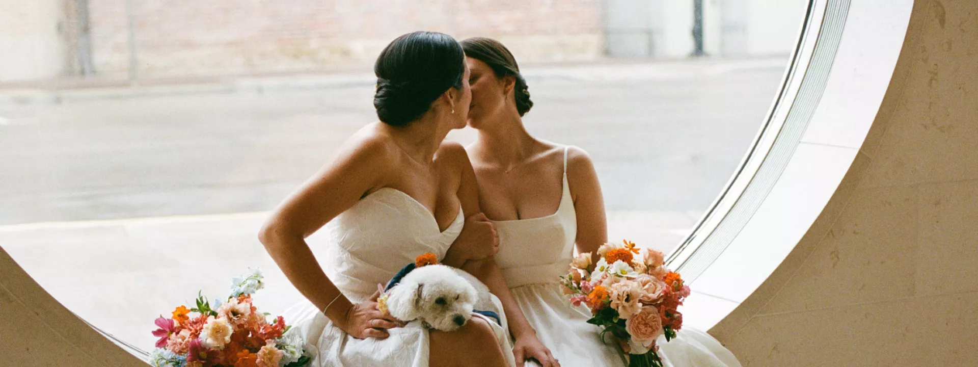 Close up of Caroline and Amy cozy up with their dog on their wedding day at Overture Center for the Arts
