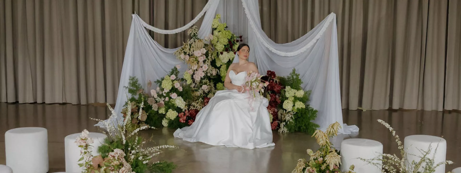 Model poses amidst florals and drapery in imagined ceremony at Abbey Road Farms