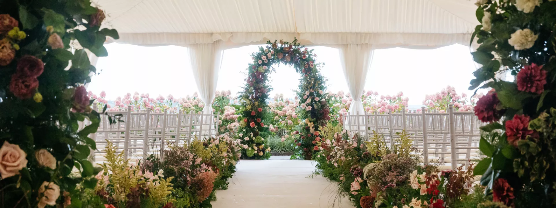 Floral lined aisle and altar in tented ceremony at Woodmark Hotel & Still Spa