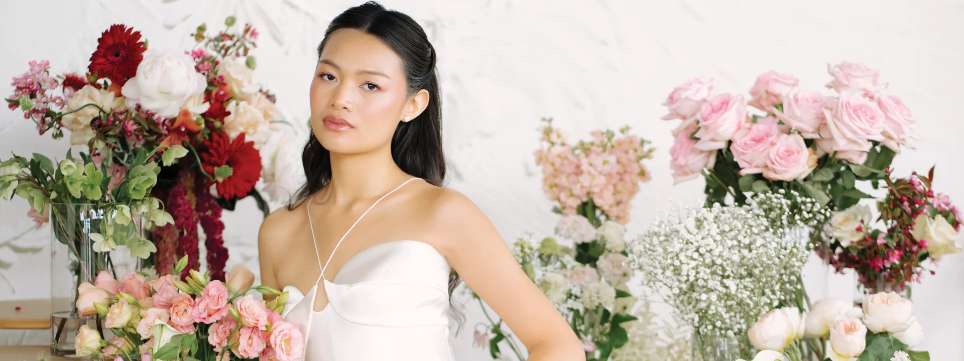 Model poses surrounded by a variety of blooms