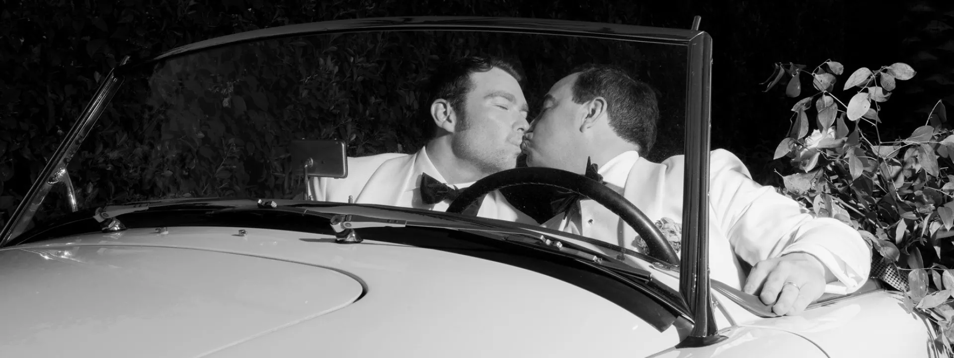 James and Timmy share a kiss in their floral decorated vintage getaway car