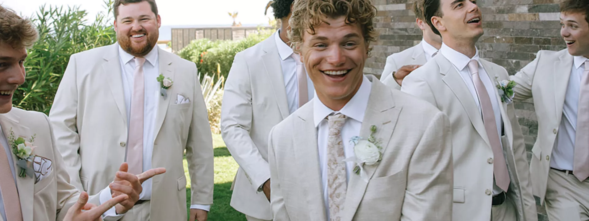 Groomsmen smile and pose playfully 
