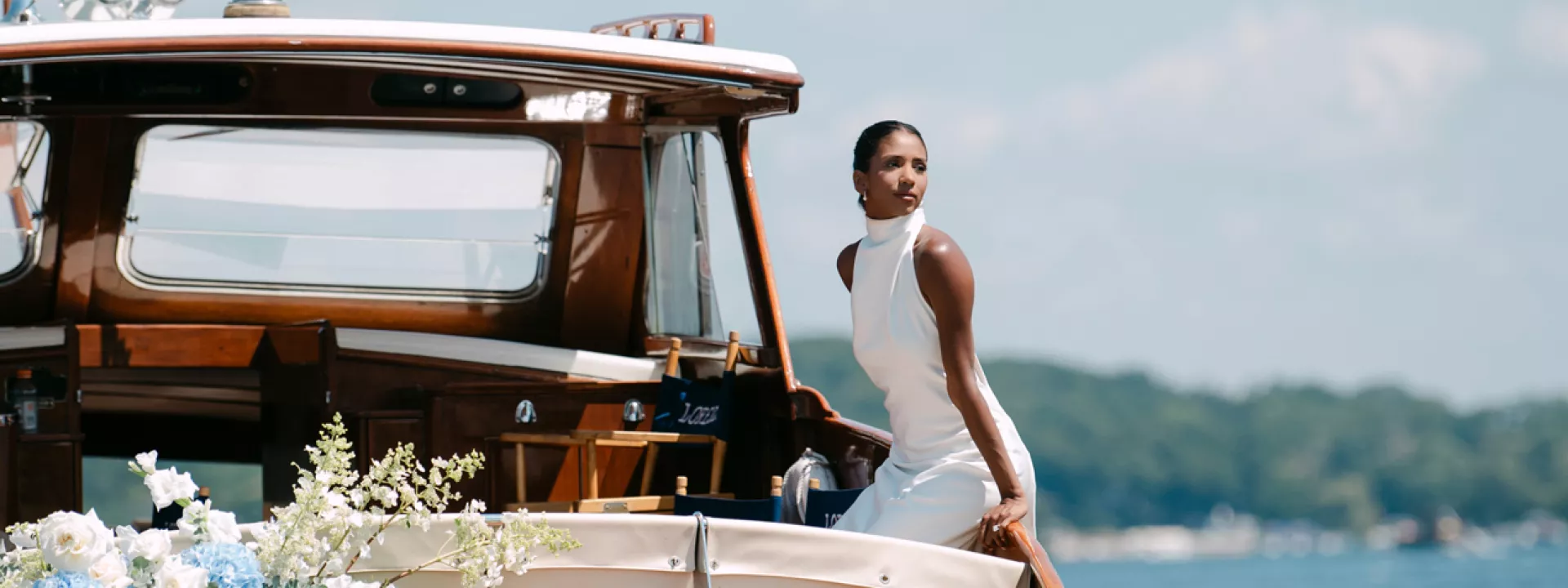Model poses on a boat decorated in florals floating on Lake Geneva outside of The Abbey Resort