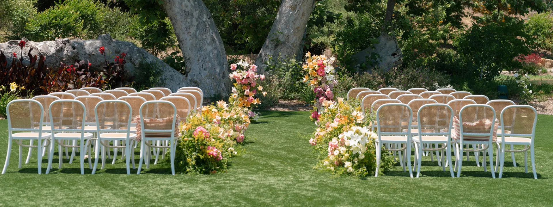 Outdoor ceremony set up featuring peachy florals on the grounds of Monserate Winery