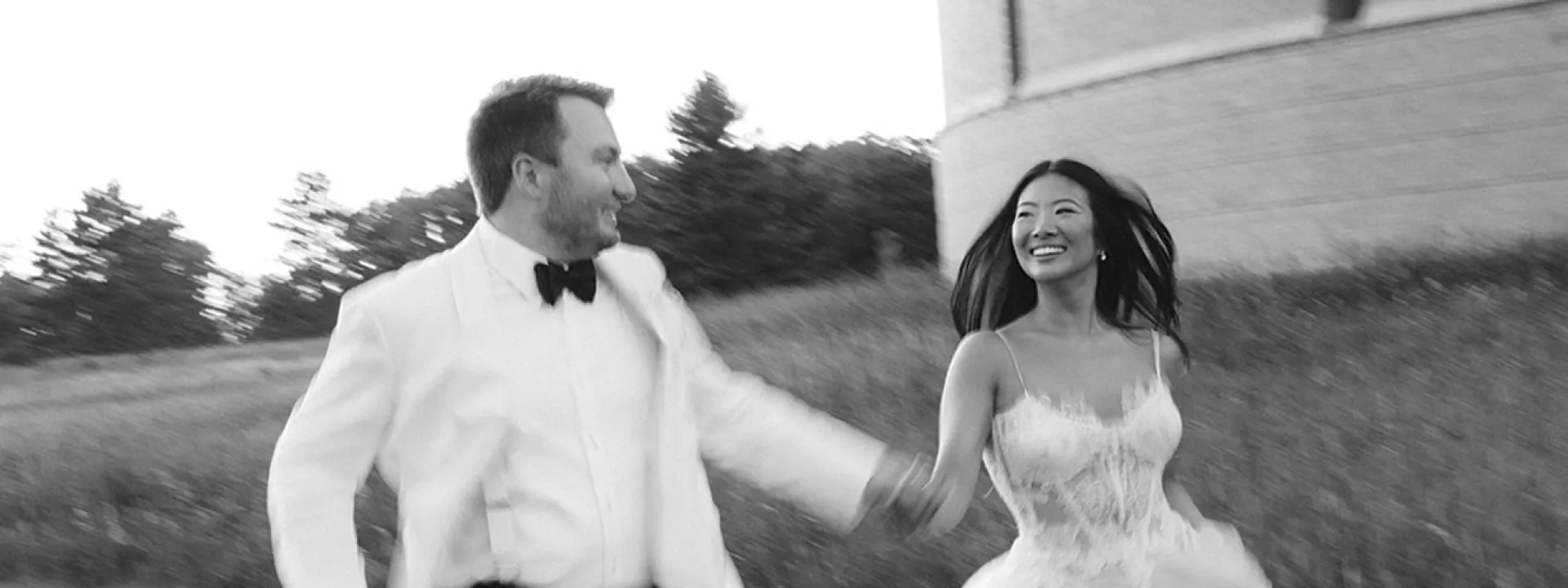 Bride and groom frolick through the grounds outside of Yerkes Observatory hand in hand on their wedding day