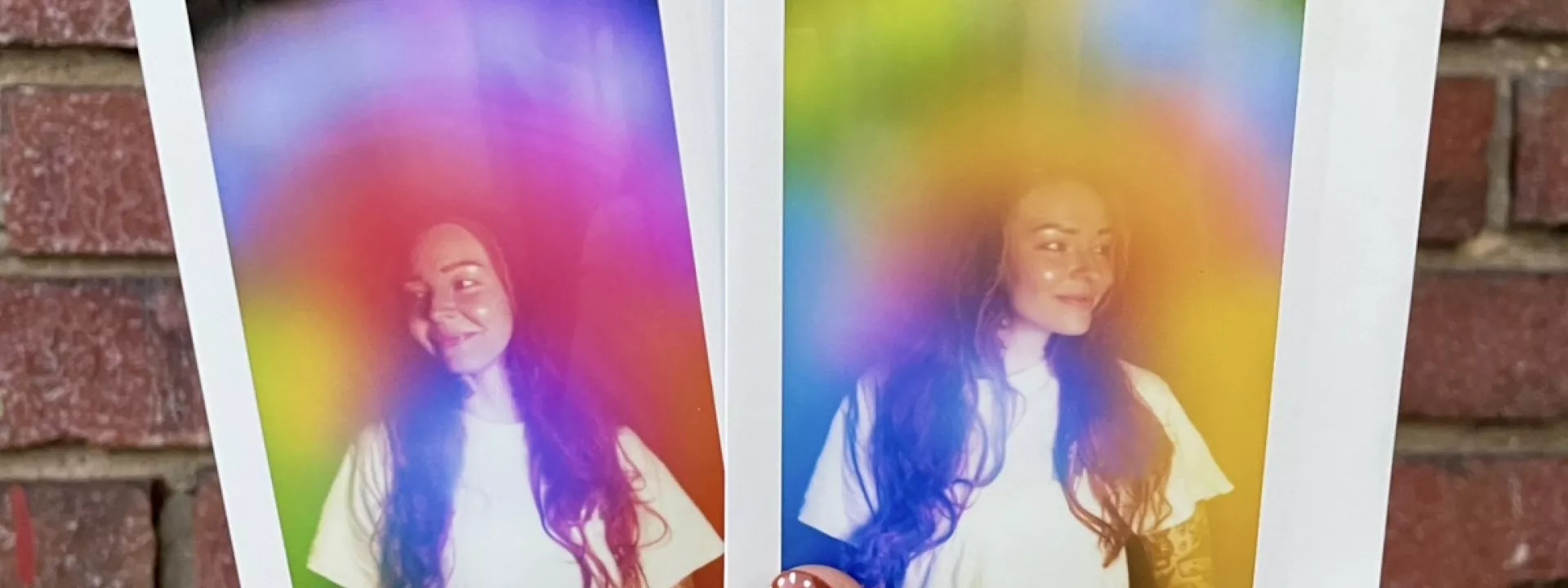Two physical aura photograph polaroids by Vivid violet Aura side by side against a brick wall