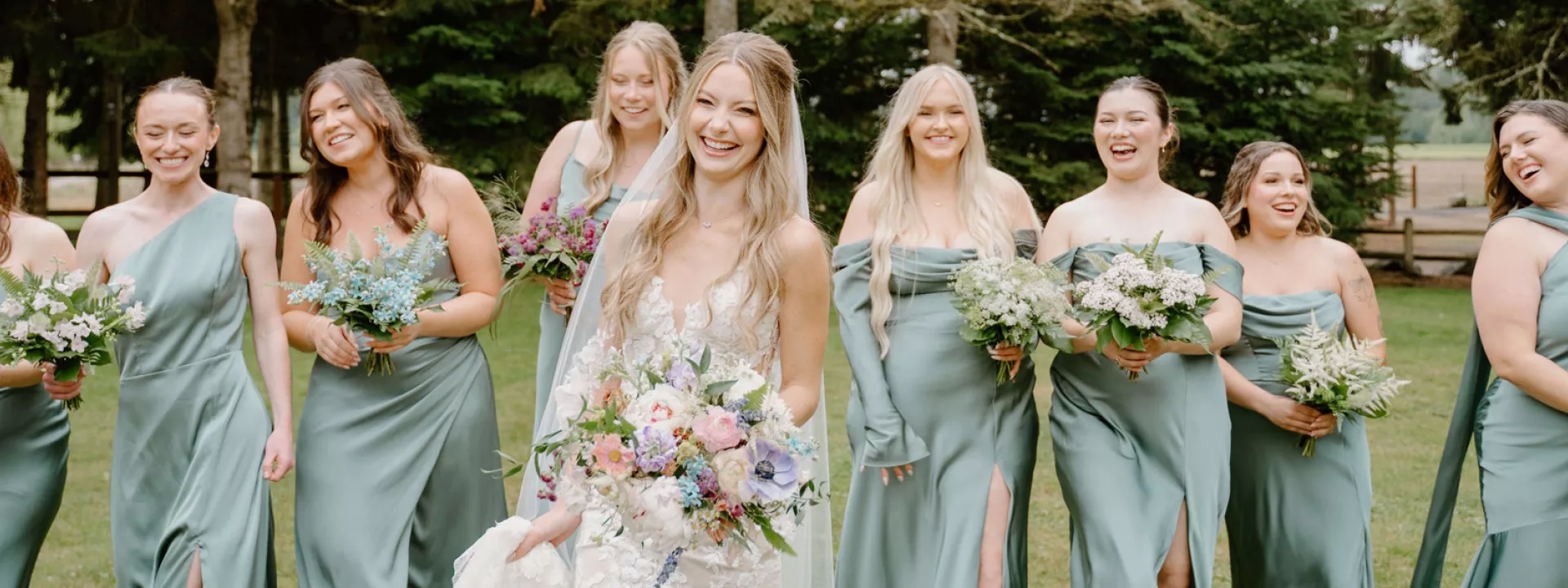 Bride walking the grounds of Woodland Meadow Farms alongside her sage-clad bridesmaids 