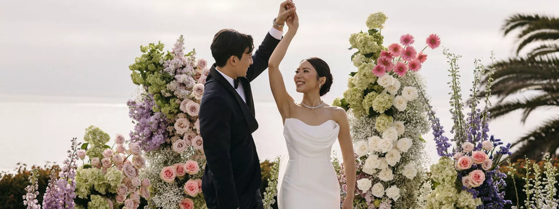 Groom spins bride on lush altarspace platform on their wedding day at Montage Laguna Beach