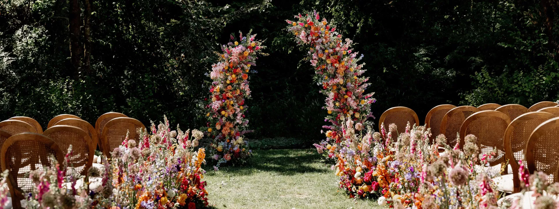 Bold abundance of blooms line the outdoor aisle in wedding day at Fox Hollow Farms