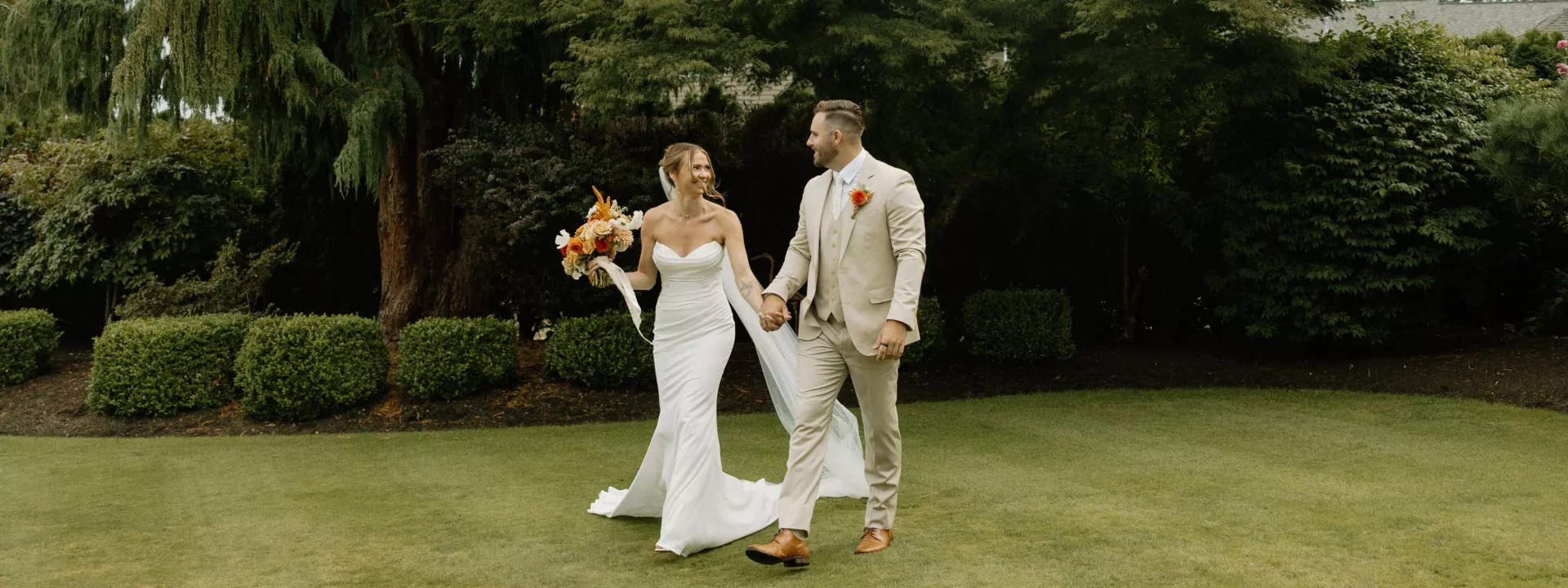 Sarah and Josh walk the grounds of the bride's childhood home on their lakeside wedding day