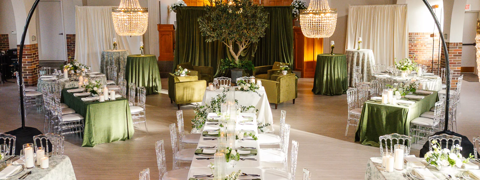 Reception scene inside Westlin Hall featuring classic design in ivory and green hues, dramatic draping and sparkling chandeliers