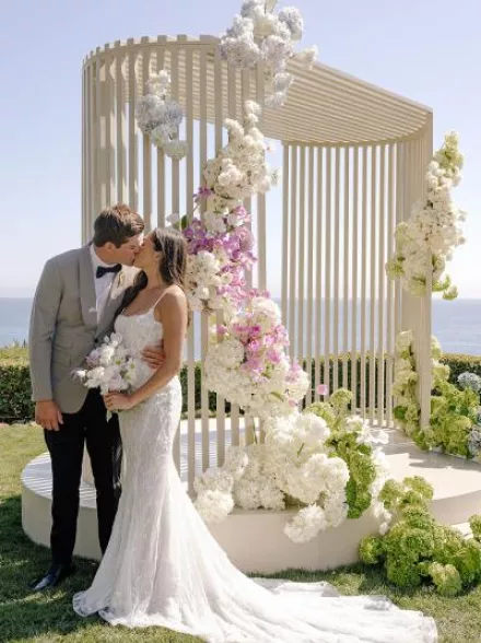 Ella and Caden share a kiss by their custom made modern altar 