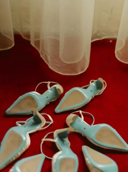 Six pairs of Valentina Rangoni designed shoes, soles up on a red carpet 