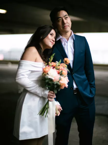 Bride Holding Bouquet and Resting Head on Husband's Shoulder