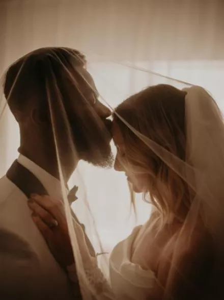 Groom kiss bride's forehead in close up shot in private wedding portrait session