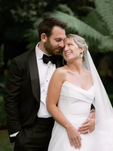 Sophie and Andrew pose side by side in their wedding attire
