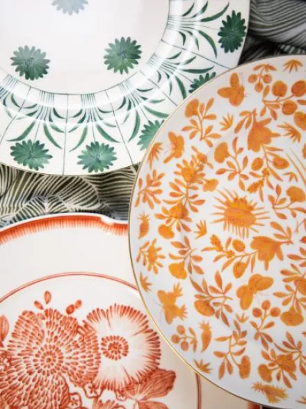 Layered fine china plates from Maison de Carine featuring floral and botanical patterns in coral, green, and orange hues—styled for the 2025 Met Gala
