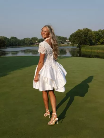 Bride walking on golf course in her mother's reworked bridal gown