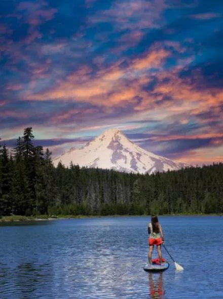 Paddle boarder on a lake with mountain in the background