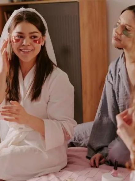 Bride and bridal party wearing robes and skincare eye masks during a relaxing wellness bachelorette party at home